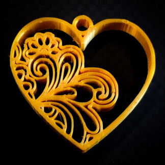 Heart-shaped, gold-colored pendant with ornamental inner design